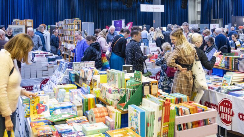 Tampereen Kirjafestarien Sorsapuistosalin jättikirjakaupassa suuri määrä ihmisiä ostoksilla ja tutkimassa valikoimaa.